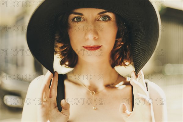 Glamorous Caucasian woman holding hat