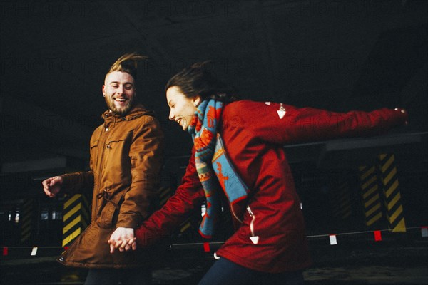 Caucasian couple running in wind