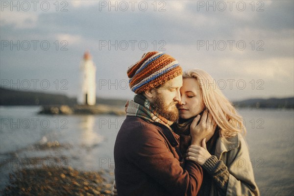 Caucasian couple hugging at beach