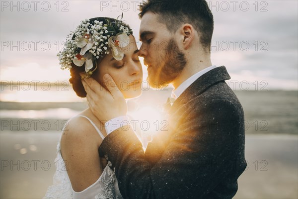 Caucasian bride and groom on sunny beach