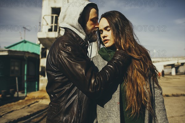 Caucasian man hugging woman outdoors