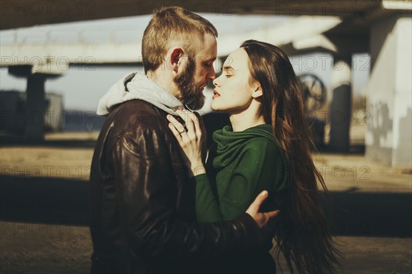 Caucasian couple hugging woman outdoors