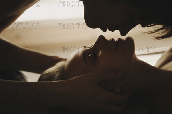 Caucasian man leaning over face of woman