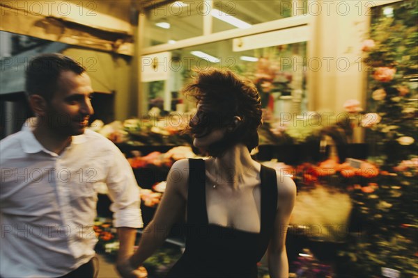 Caucasian couple rushing near florist