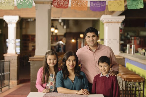 Portrait of smiling Hispanic family in restaurant