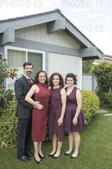 Family posing near house