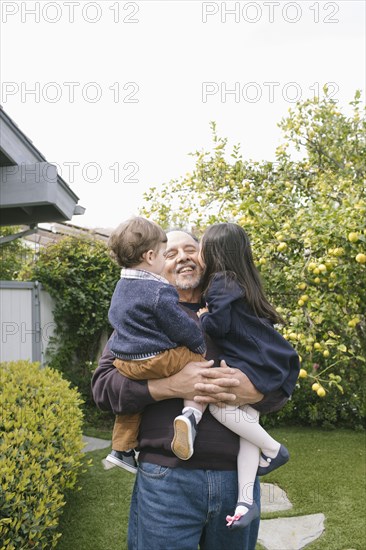 Boy and girl kissing grandfather