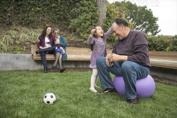 Granddaughter playing with head of grandfather