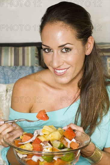 Hispanic woman eating healthy salad