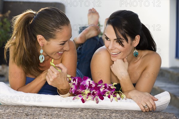 Hispanic friends laying outdoors talking