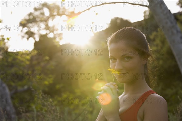 Hispanic woman smelling flower