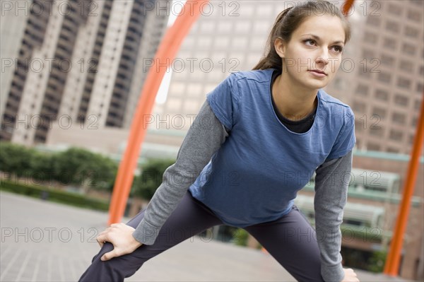 Hispanic woman stretching in urban area