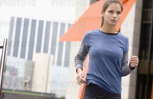 Hispanic woman running in urban area