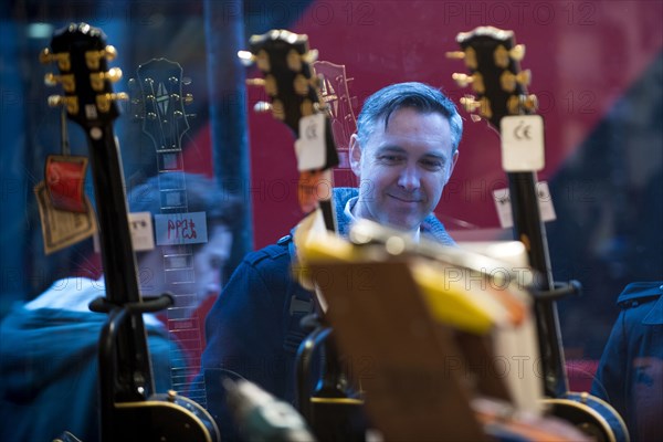 Man window shopping for guitars