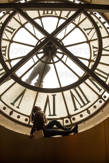 Girl sitting in clock window