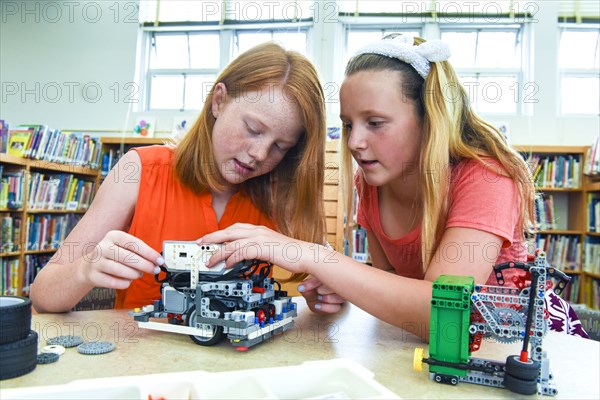 Girls assembling plastic blocks in library