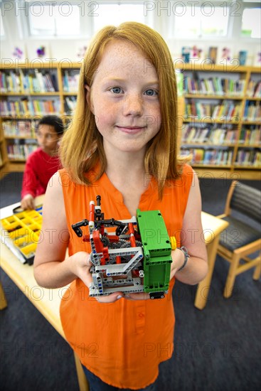 Girl posing with plastic blocks in library