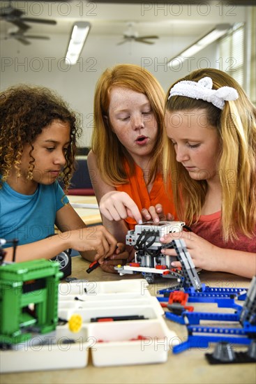 Girls assembling plastic blocks in library