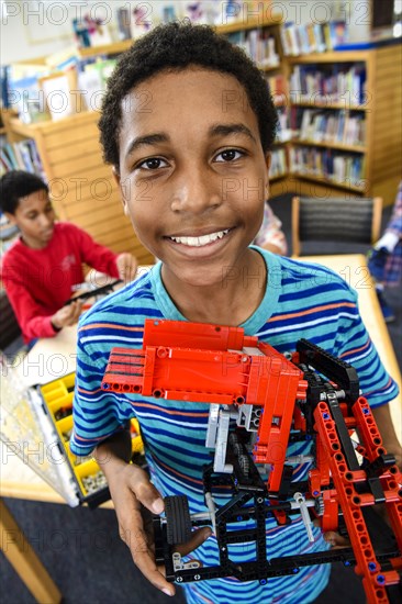 Boy posing with plastic blocks in library