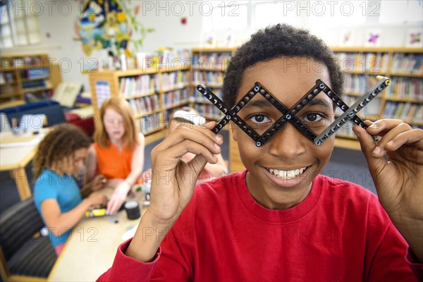 Boy playing with plastic blocks in library