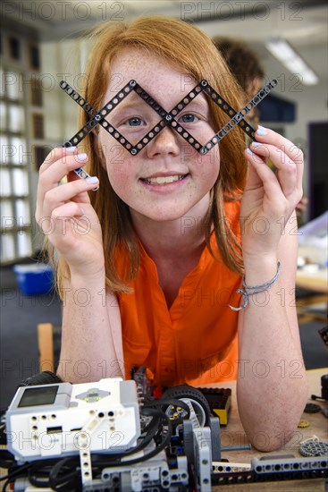 Girl playing with plastic blocks in library