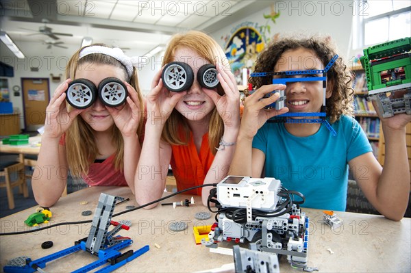 Girls playing with plastic blocks and wheels in library