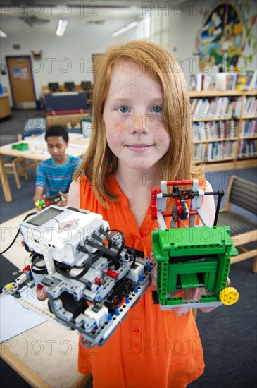 Girl posing with plastic blocks in library