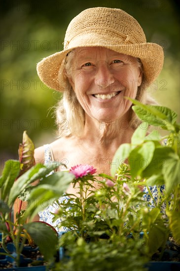 Portrait of smiling Caucasian woman holding tray of flowers