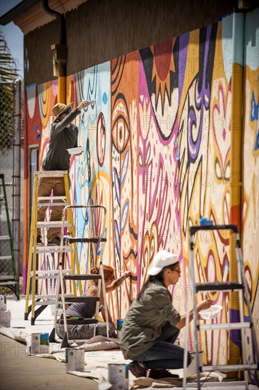 People painting mural on wall