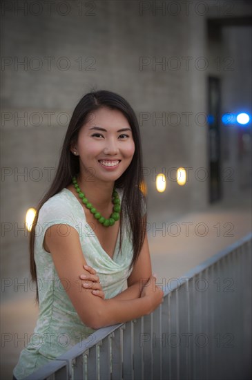 Portrait of smiling woman leaning on railing