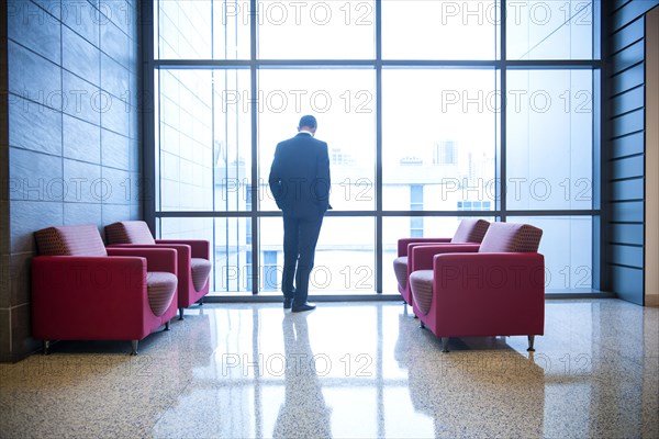 Hispanic businessman waiting in office lounge near window