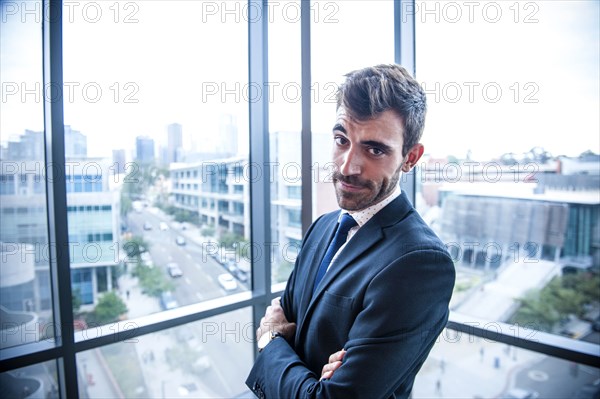 Portrait of serious Hispanic businessman posing near window