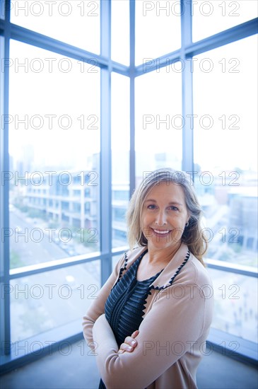 Portrait of smiling Caucasian businesswoman posing near window