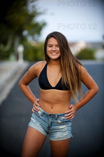 Portrait of smiling Pacific Islander girl wearing bikini in street