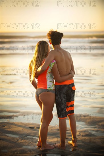 Teenage boy and girl hugging on beach