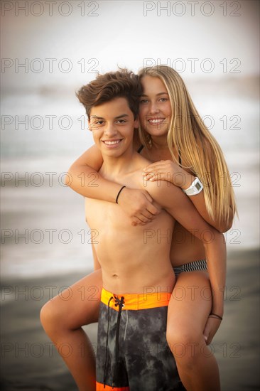 Portrait of teenage boy carrying teenage girl piggyback