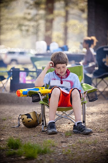 Caucasian boy reading book at campground