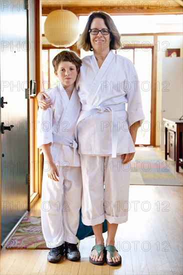 Portrait of Caucasian mother and son wearing martial arts clothing
