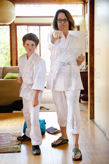 Portrait of Caucasian mother and son wearing martial arts clothing