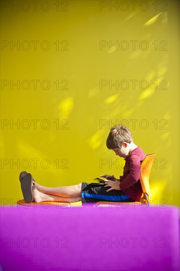 Caucasian boy relaxing and reading digital tablet