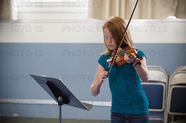 Caucasian girl practicing violin