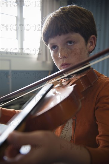Close up of Caucasian boy practicing violin