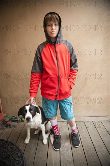 Portrait of Caucasian boy standing with dog