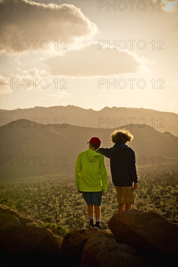 Boys standing on rock admiring desert landscape