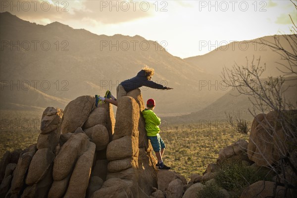 Boys standing on rocks admiring desert landscape