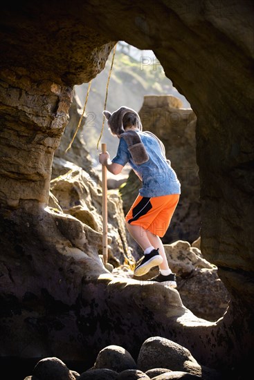 Caucasian boy hiking on rocks
