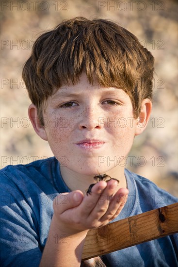 Portrait of Caucasian boy holding crab in hand