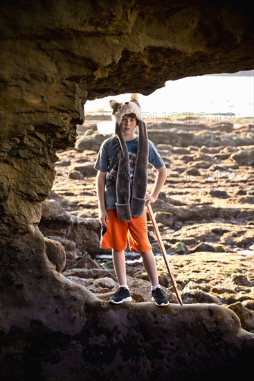 Portrait of Caucasian boy hiking on rocks at beach