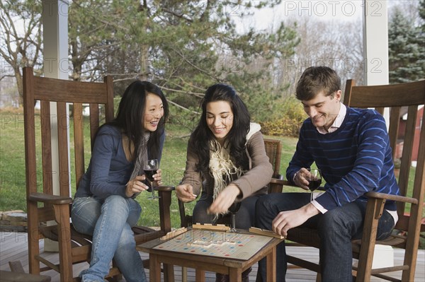 Friends playing scrabble on porch