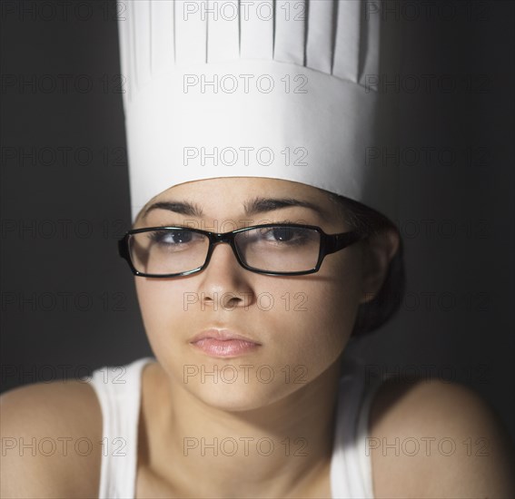 Hispanic woman in chef's hat and eyeglasses